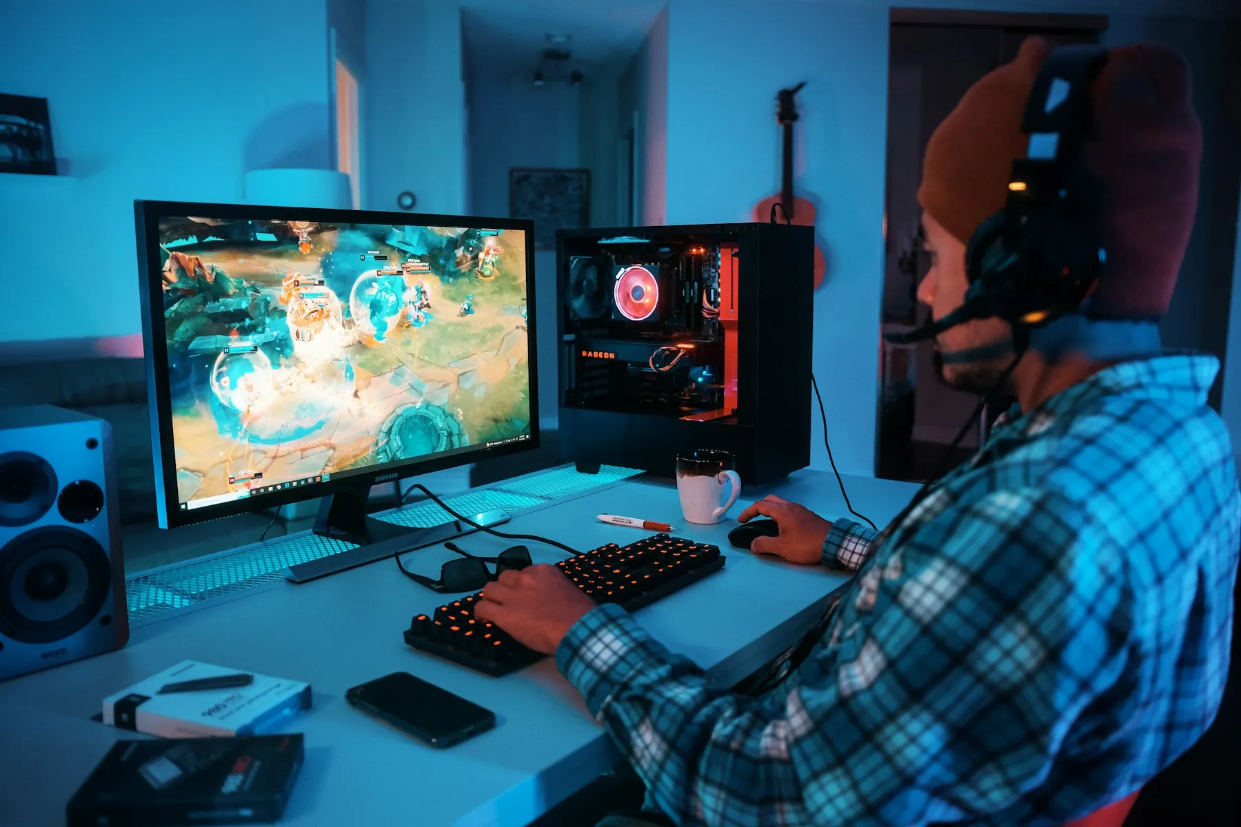 A player wearing headphones at a computer